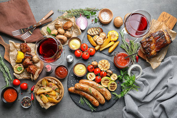 Delicious meal served for barbecue party on gray table, flat lay