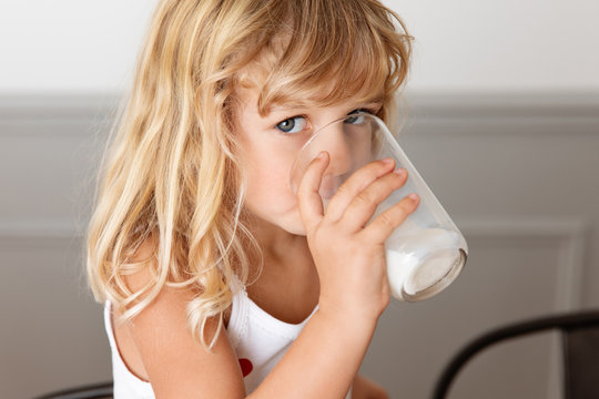 Little Girl Drinking A Glass Of Milk