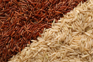 Different types of brown rice as background, top view