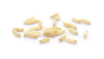 Scattered grains of brown rice on white background