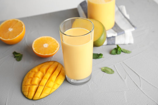 Fresh mango drink and tropical fruits on table