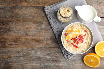 Flat lay composition with quinoa porridge, cream and space for text on wooden background