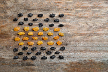 Flat lay composition with raisins and space for text on wooden background. Dried fruit as healthy snack