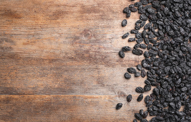 Many raisins and space for text on wooden background, top view. Dried fruit as healthy snack