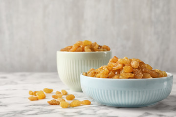 Bowls with raisins on marble table. Dried fruit as healthy snack