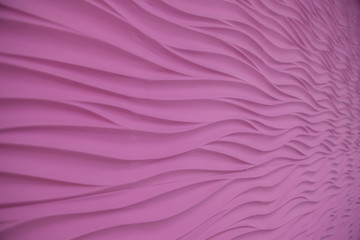 Fototapeta na wymiar Volumetric wavy patterns on the pink wall