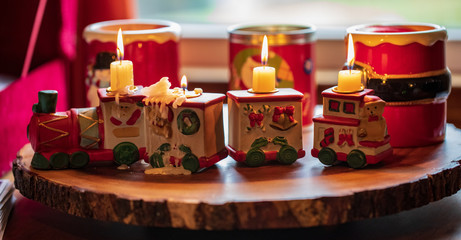 candle holding train with big holiday candles in background 