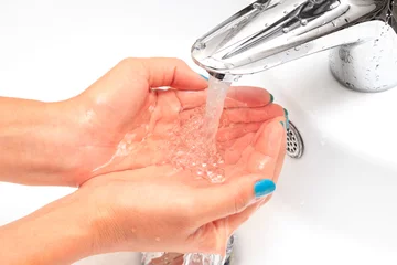 Female hands under running water in the sink © nakedking