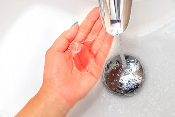 Liquid soap in a woman's hand in the sink