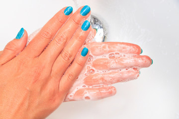 Soaped woman hands in the sink