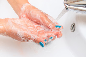 Soaped woman hands in the sink