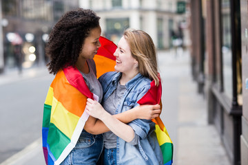 Obraz premium Happy lesbian couple with a LGBT flag