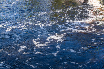 Foamy streams of water Tahmayoki River on the waterfall Ahinkoski