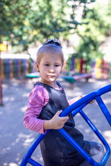 Fototapeta na wymiar Little cute girl on the playground in the summer