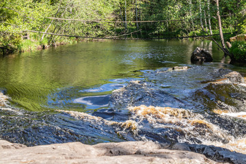 Fototapeta na wymiar Foamy streams of water Tahmayoki River on the waterfall Ahinkoski