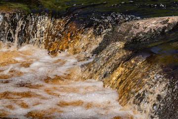 Foamy streams of water Tahmayoki River on the waterfall Ahinkoski