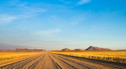 Fototapeta premium empty dirt road across the the Namibian Desert.
