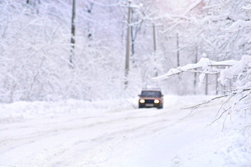 Deep winter scene on a country frozen road with car. Blurred background.