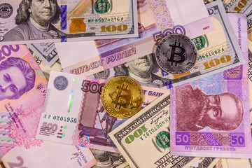Bitcoin coins on the american, ukrainian and russian banknotes