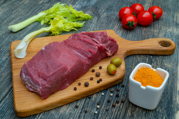 slice of raw fresh lean beef on a meat cutting board.