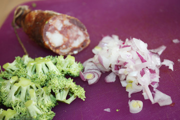 Obraz na płótnie Canvas Hunting sausage with broccoli and onion on the kitchen desk. 