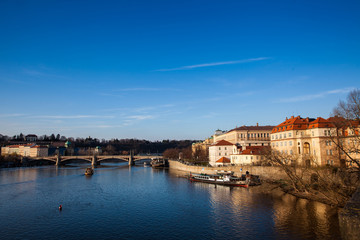 Golden light over the beautiful old town of Prague city during sunset at early spring seen from Charles Bridge