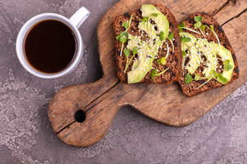 Healthy rye toasts with avocado, radish sprouts and sesame