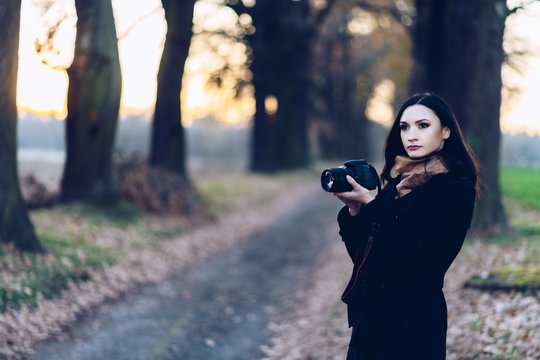 Young brunette woman taking photos with dslr