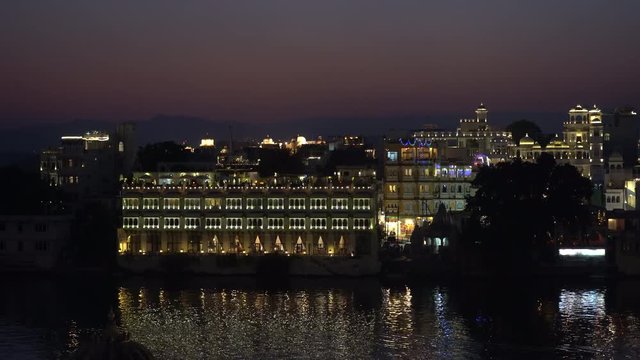 Night view on architecture and lake water in Udaipur, Rajasthan, India, establishing shot. Udaipur is one of the most visited tourist destinations in India.