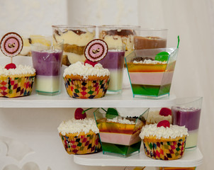 Different fruit desserts with fruits in glasses on the table. Restaurant presentation, food, party concept