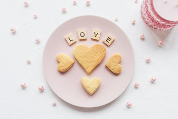 LOVE word and heart shaped cookies on a pink plate