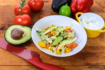Mixing Tropical Salad of Mango and Avacado on Rustic Wooden Cutting Board