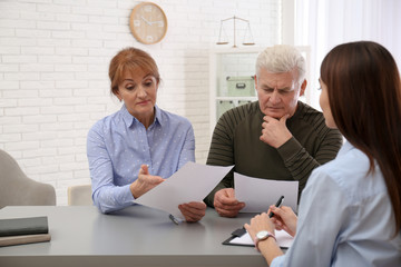 Young lawyer consulting senior couple in office