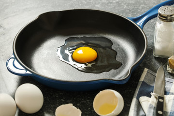 Raw chicken egg in a frying pan.