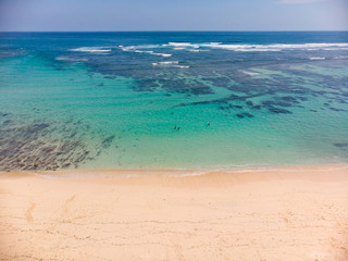 Obraz premium Vertical view of Pandawa Beach , Bali with some people in the water for scale