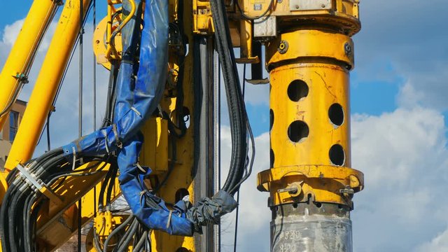 Heavy big excavator break trough holes for concrete colones for new road in construction site. Building a new streets in urban area, city town