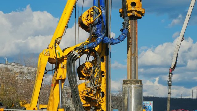 Heavy big excavator break trough holes for concrete colones for new road in construction site. Building a new streets in urban area, city town