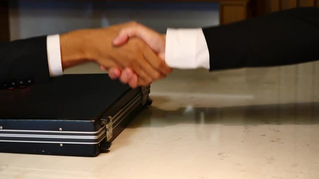 Business man giving something in a briefcase while give success the deal to finishing contract agreement