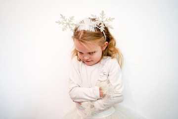 portrait of a angry little girl in front of white wall