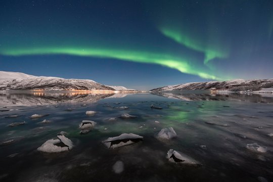 Northern lights over fjord with ice floes, island of Senja, Troms, Norway, Europe