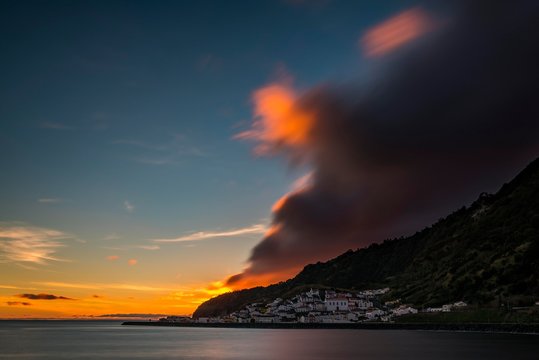 Small village by the sea, sunset with dramatic clouds behind mountain ridges, Ribeira Quente, Sao Miguel, Azores, Portugal, Europe