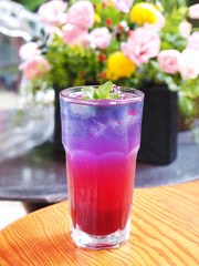 Butterfly pea flower iced tea in glass on wooden table 