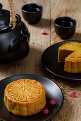 Delicious food moon cake with cup of hot tea on the the wooden table background with copyspace for your text, Chinese traditional festival concept
