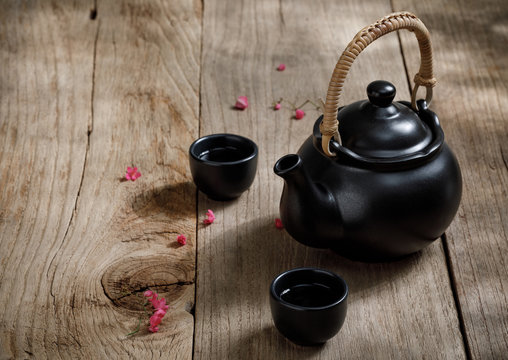 Cup of hot tea with steaming jugs on the wooden table background with copyspace for your text, Chinese style