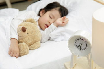 Child girl sleeping with teddy bear on the wooden bed in her bedroom, Happy asian child little girl...