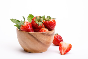 Red berry strawberry in a wooden bowl isolated on white background. Strawberries with leaves in a wooden bowl. Isolated