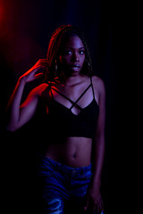 Black woman in studio with colored lights