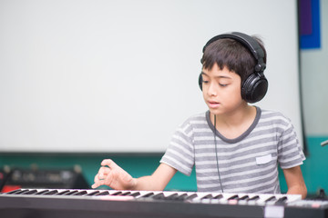 Asian little boy play piano  study music classroom