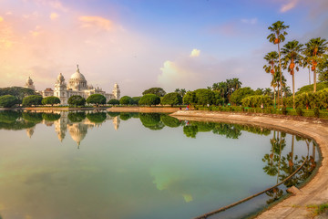 Scenic Victoria Memorial Kolkata at sunrise with water reflection.