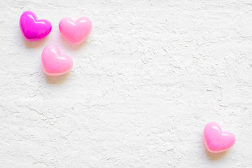 Valentine day background with pink hearts on grunge white wood background, top view with copy space. Flat lay minimal style image.